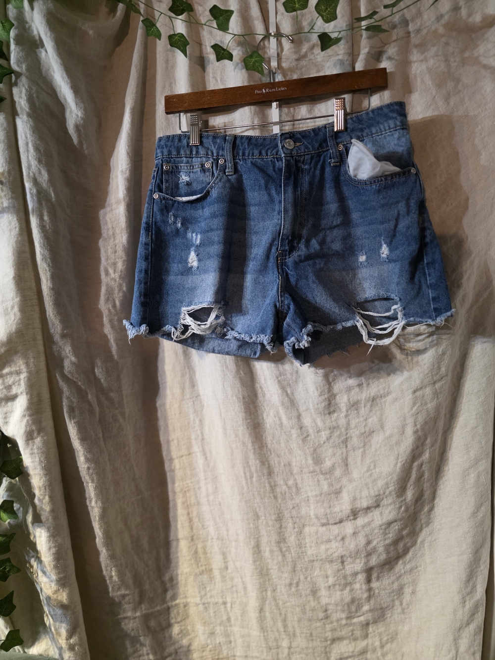 Classic medium wash denim shorts with stylish distressed details and a raw fraye